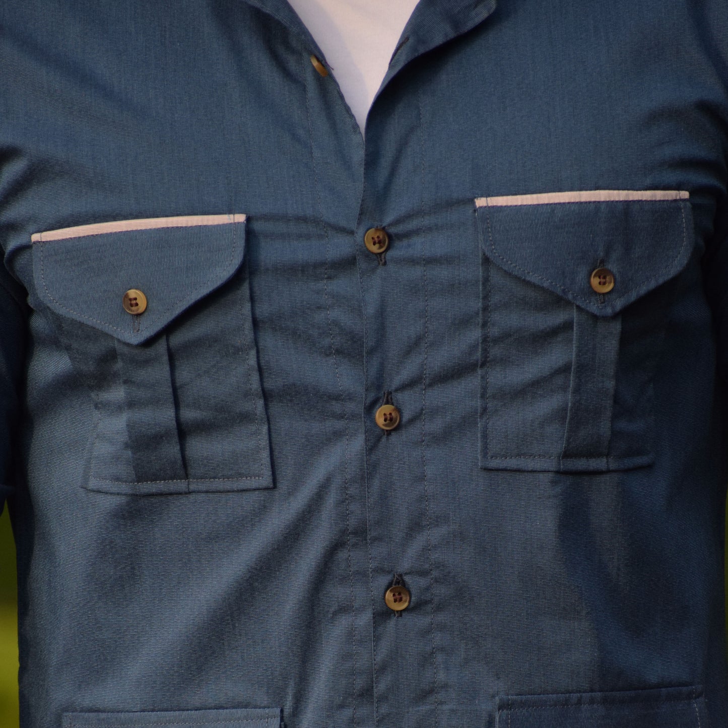 Close-up of a blue shirt with multiple pockets and buttons
