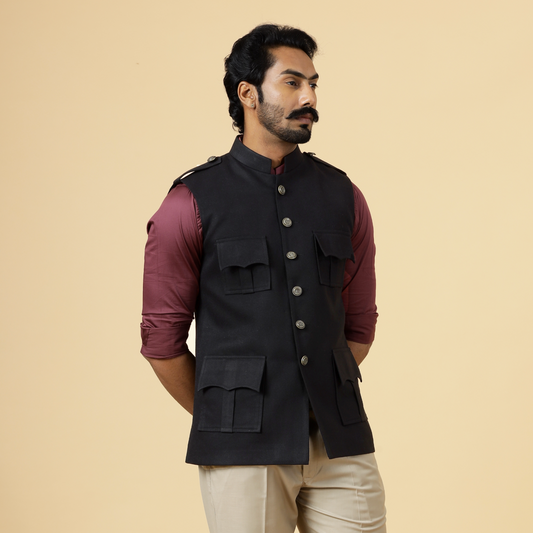 Man wearing a black vest over a red shirt on a beige background