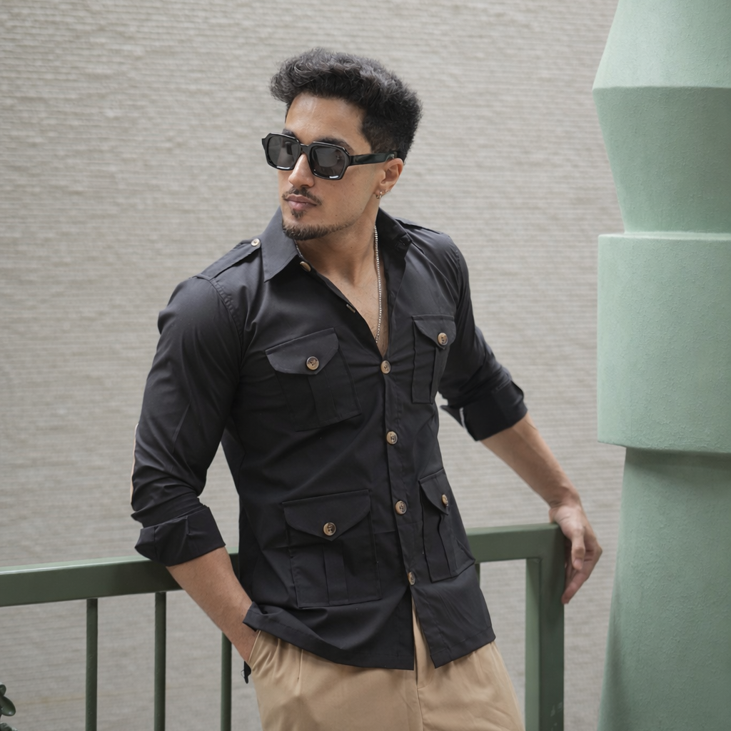 Man wearing a black hunting shirt standing against a wall