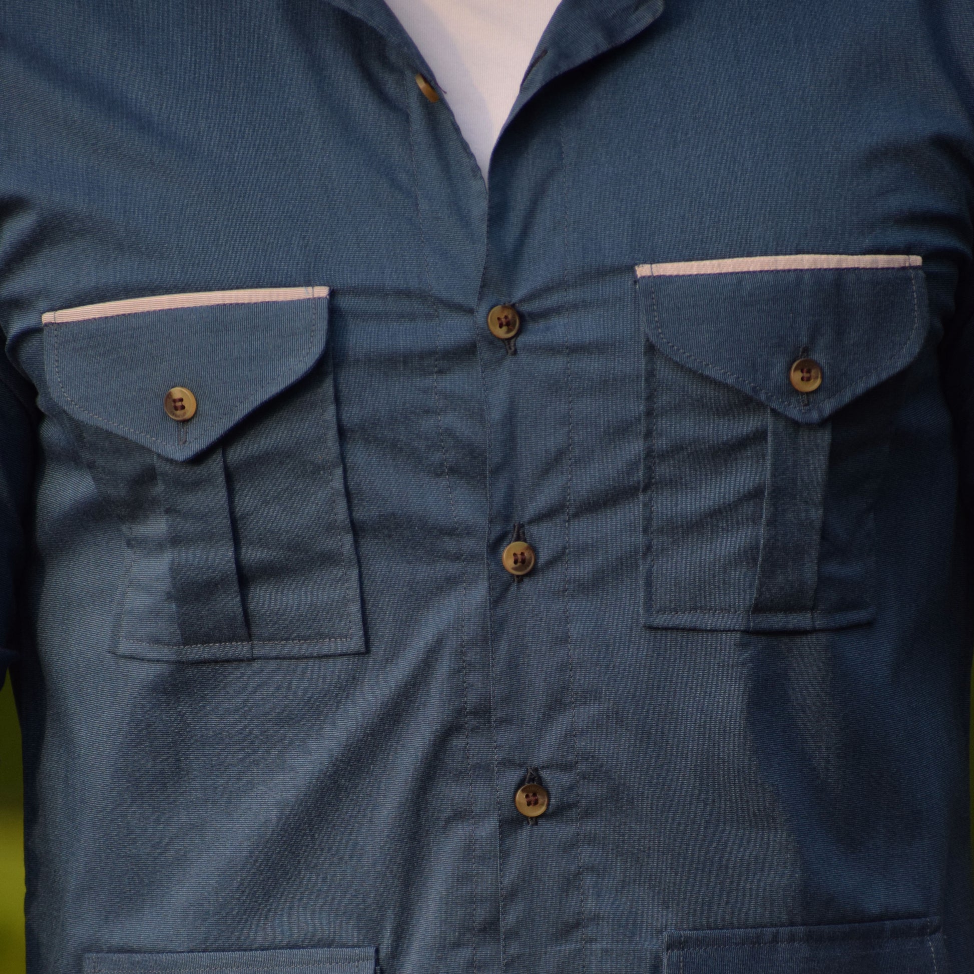 Close-up of a blue shirt with multiple pockets and buttons
