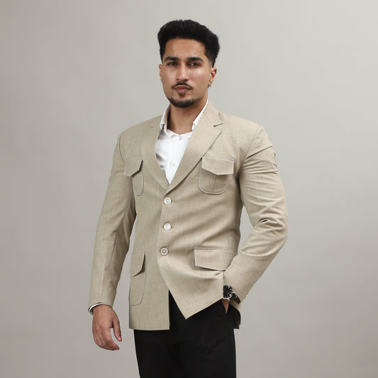 Person wearing a beige blazer and black pants on a plain background