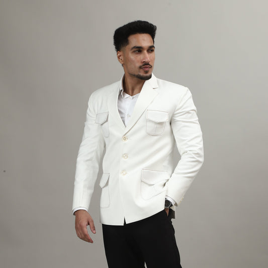 Person wearing a white jacket and black pants on a plain background