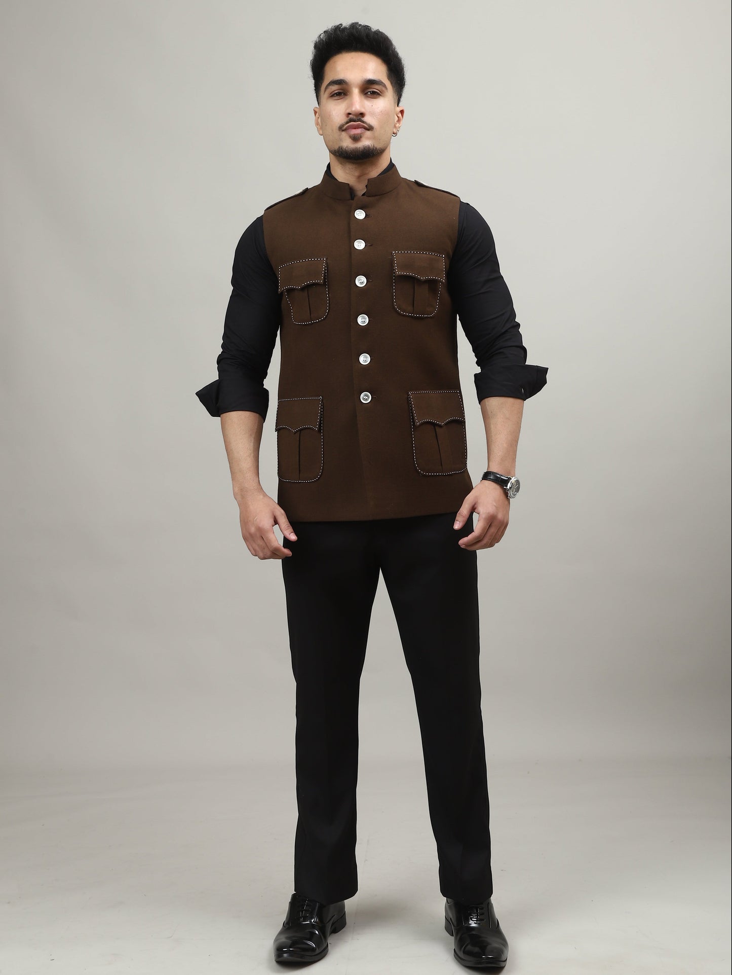 Man wearing a brown vest over a black shirt on a white background