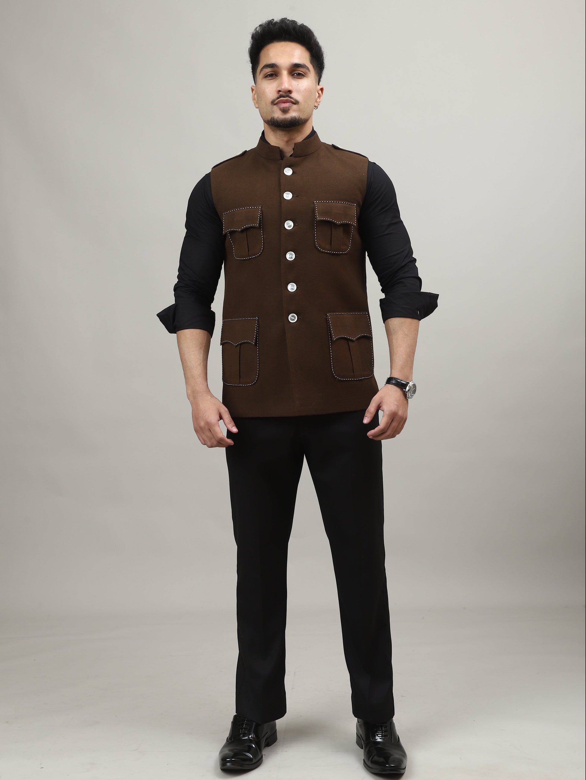 Man wearing a brown vest over a black shirt on a white background