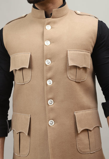 Person wearing a beige tactical vest with multiple pockets and buttons on a plain background