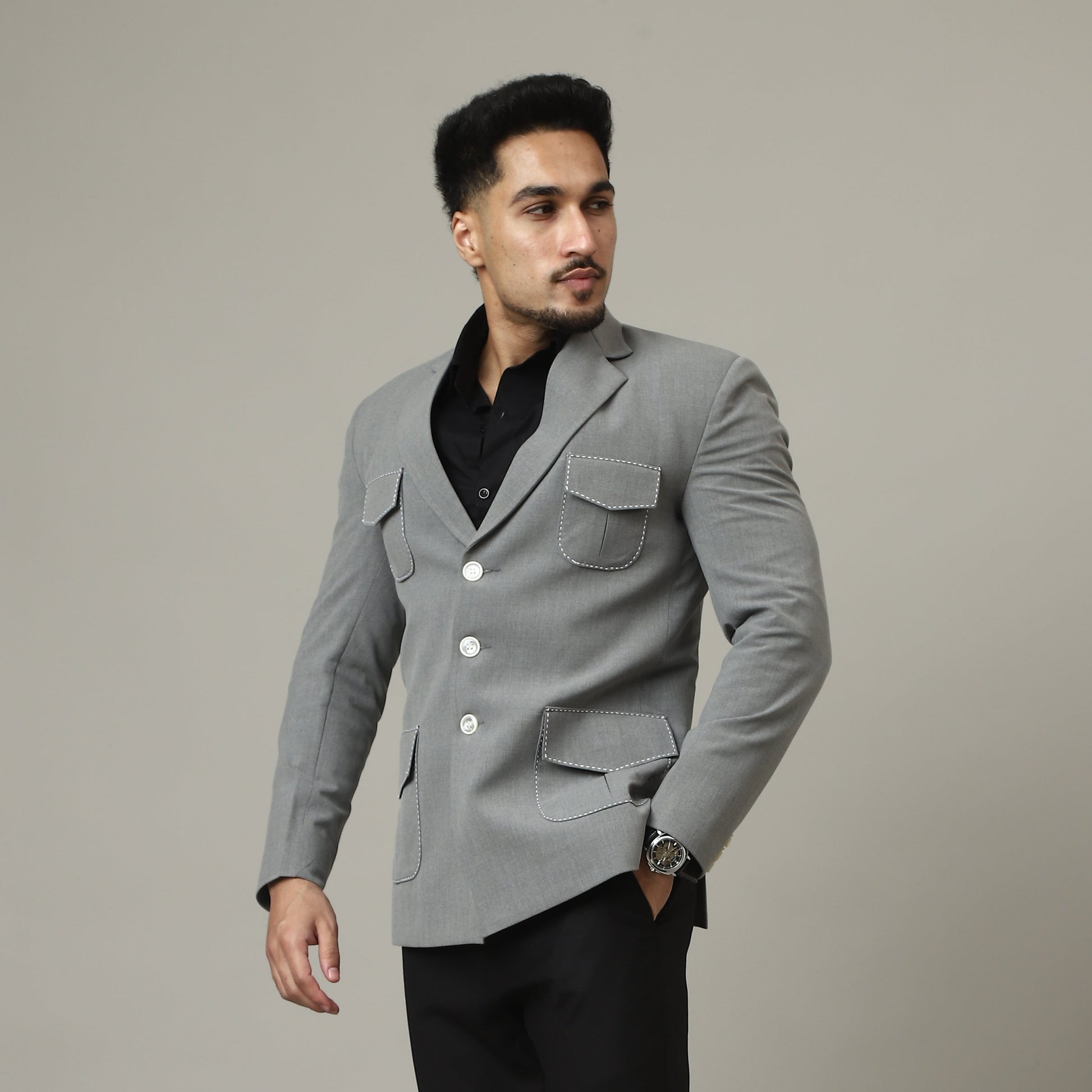 Man wearing a gray coat and black pants against a plain background