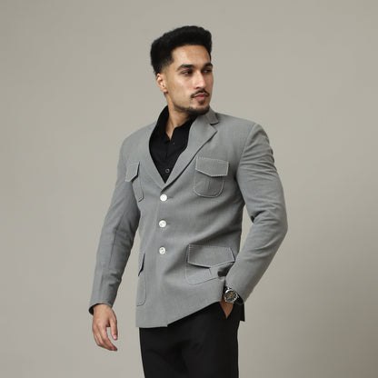 Man wearing a gray coat and black pants against a plain background