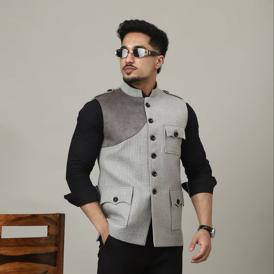 Person wearing a gray vest and black pants in an inverted position with a wooden shelf in the background.