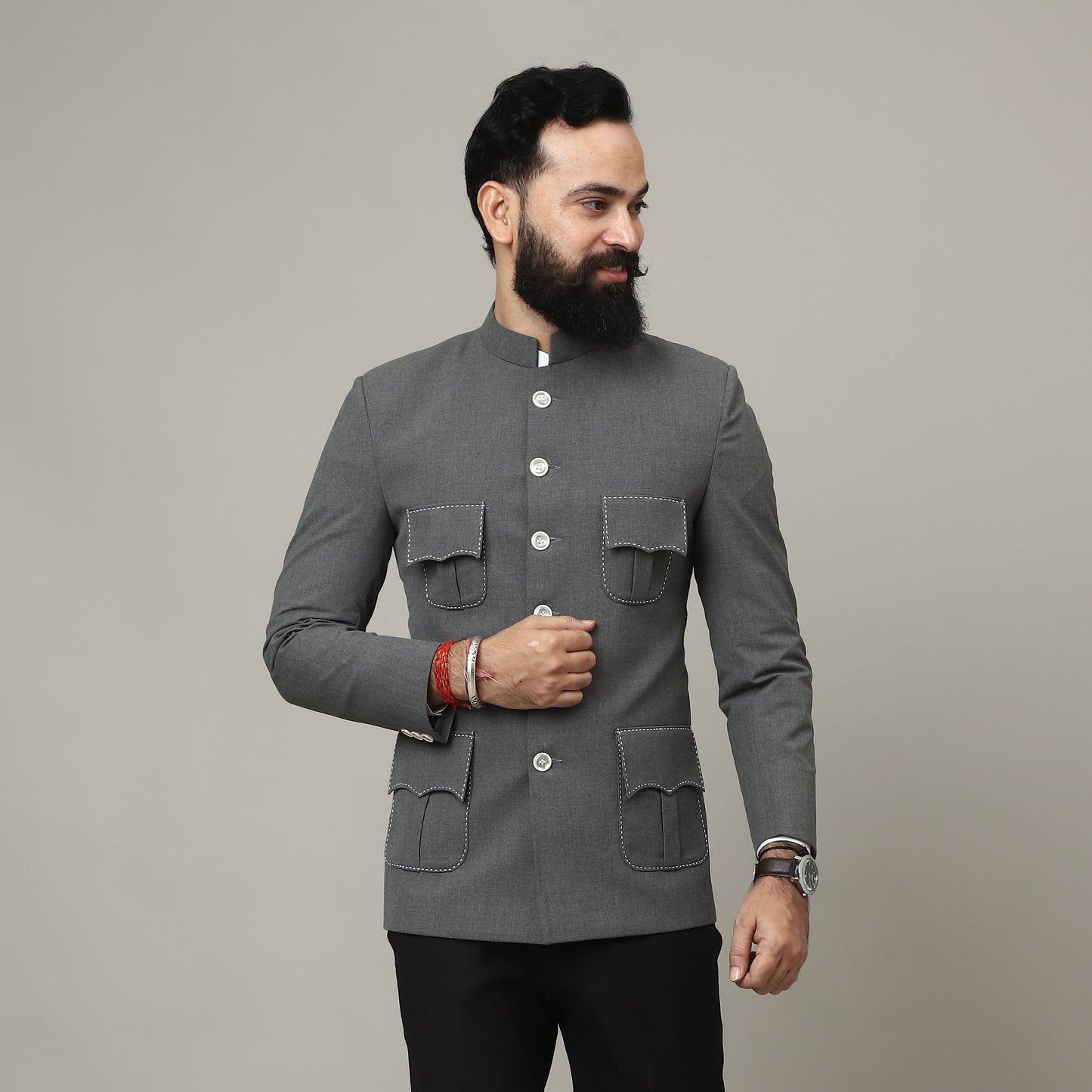 Man wearing a gray coat and black pants on a plain background