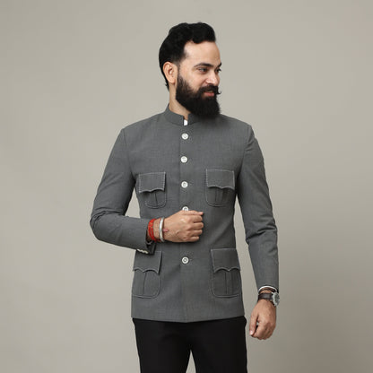 Man wearing a gray coat and black pants on a plain background