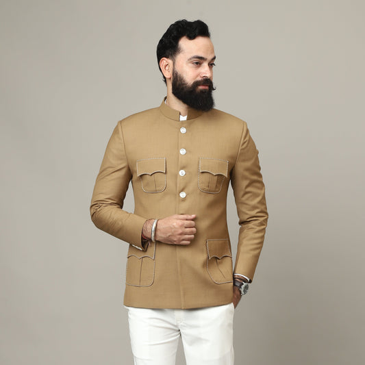 Man wearing a beige jacket and white pants on a plain background