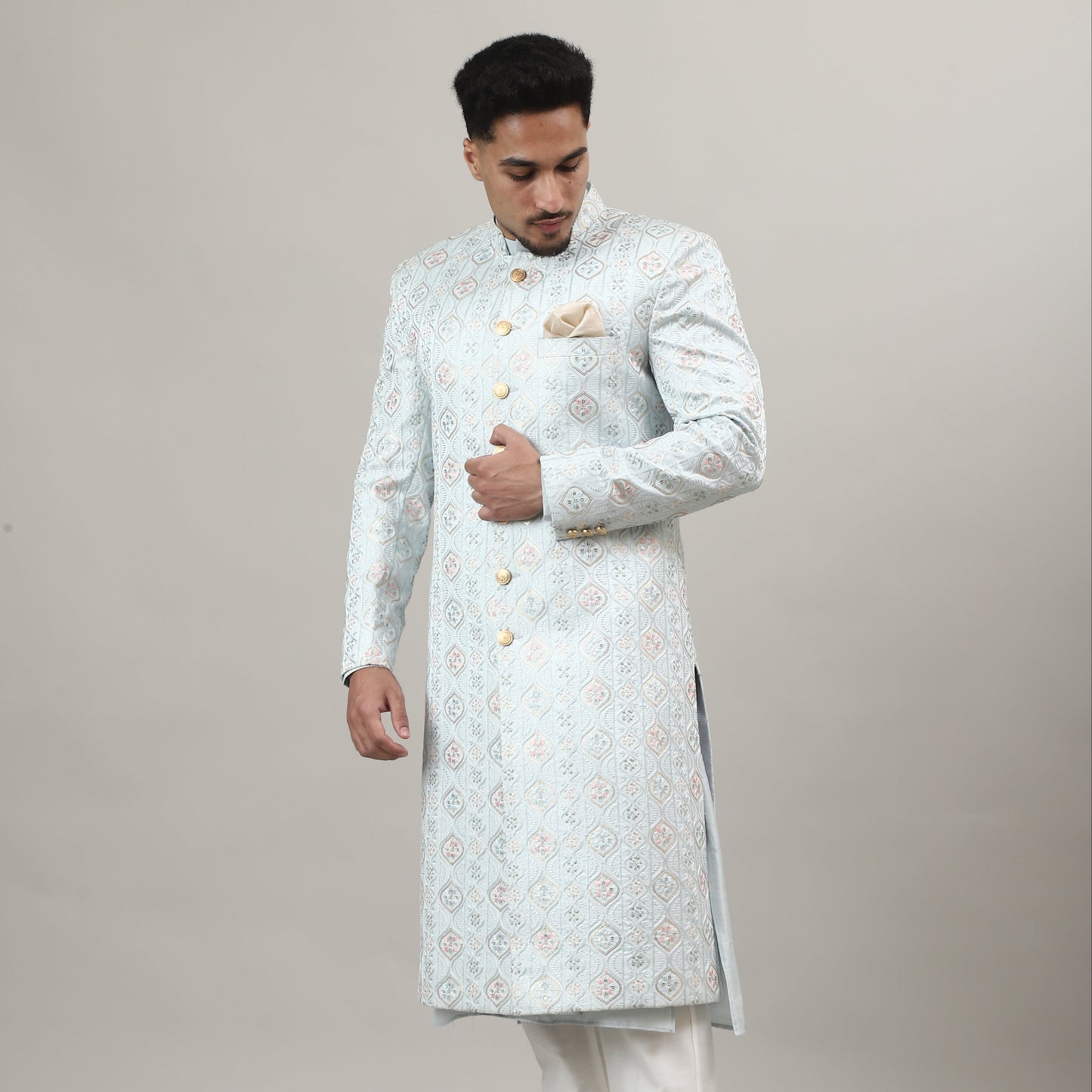 Person wearing a light-colored traditional outfit with a plain background