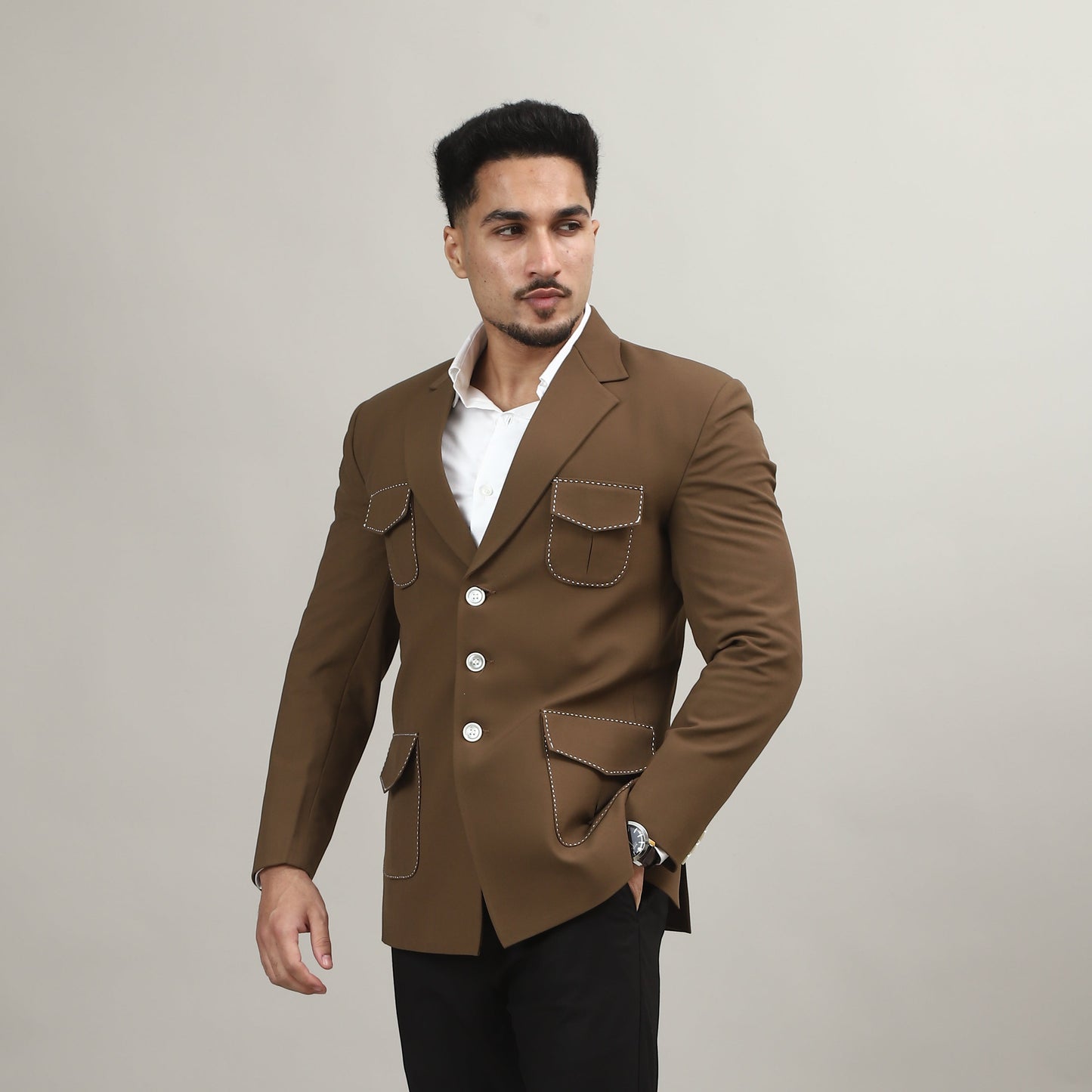 Man wearing a brown coat and black pants on a plain background