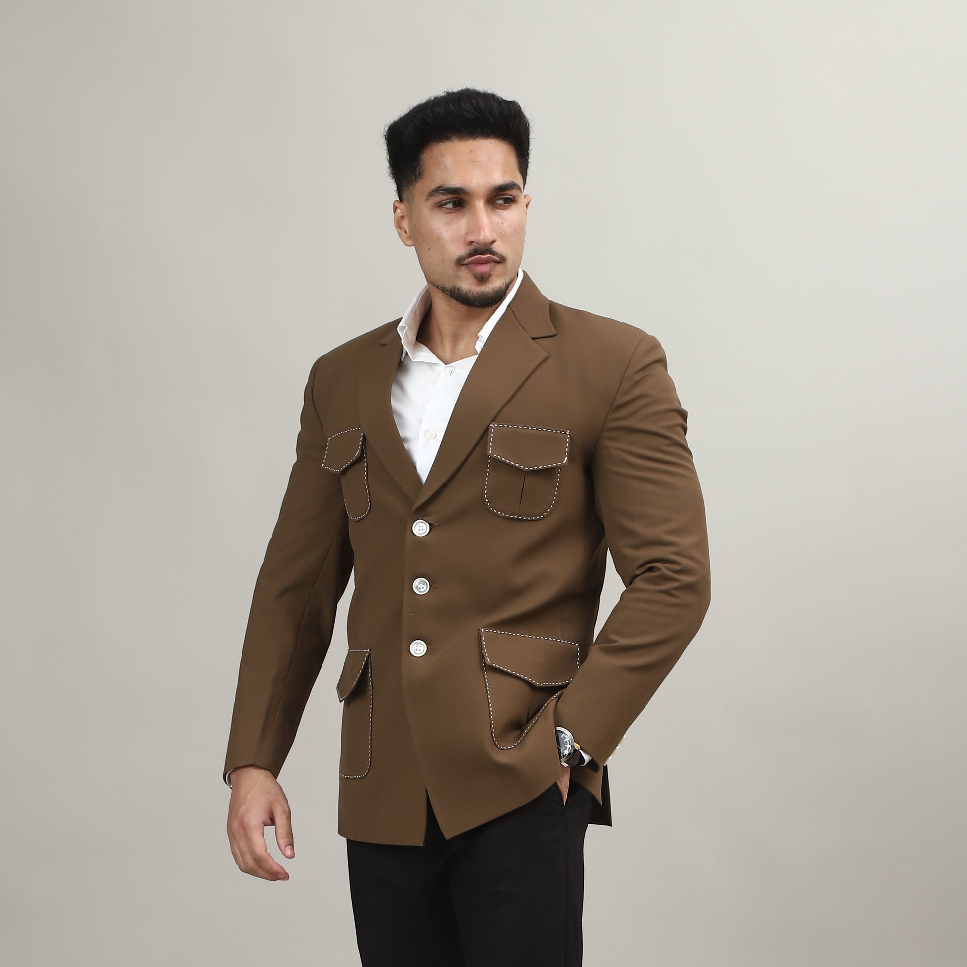 Man wearing a brown coat and black pants on a plain background